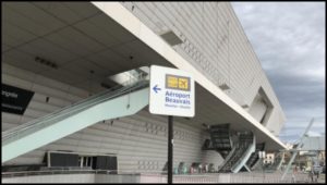 Uno dei tanti cartelli che indicano il percorso da seguire verso la stazione dei bus di Porte Maillot. Sullo sfondo il Palais des Congrès